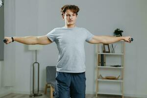 homem esporte casa Treinamento estilo de vida interior atividade saúde cinzento halteres abdômen foto