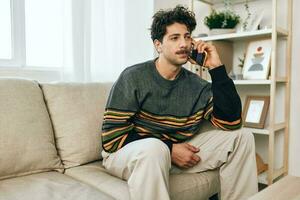 homem sentado estilo de vida casa sorrir telefone sofá célula foto