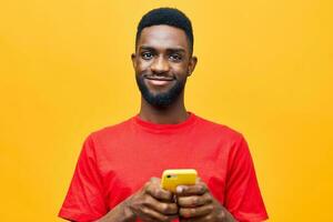 amarelo homem tecnologia fundo africano jovem telefone feliz animado Preto digitando Móvel foto
