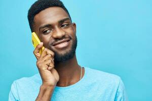 homem telefone feliz africano jovem tecnologia fundo sorrir Preto Móvel propaganda mensagens de texto foto