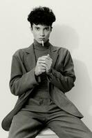 moda homem pensativo fumar retrato Preto cigarro aluna e bonito branco hipster estúdio face sentado foto