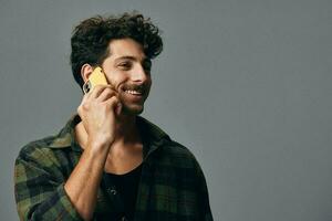 homem feliz à moda estilo de vida sorrir fundo estúdio cinzento telefone foto