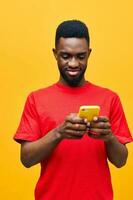 homem Preto Móvel amarelo fundo mostrando telefone retrato tecnologia africano feliz jovem foto