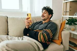 homem digitando comunicação telefone telefone tecnologia freelance Smartphone estilo de vida mensagem casa Móvel sofá foto