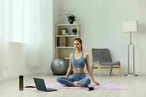 mulher halteres lótus computador portátil esteira Treinamento ioga saúde vídeo casa estilo de vida foto