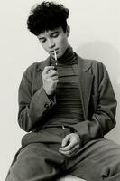 moda homem cigarro olhando Preto aluna bonito fumar sentado pensativo retrato e hipster face branco foto