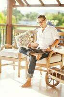 jovem homem relaxante e lendo uma revista foto