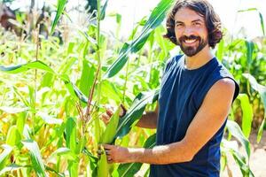 jovem homem jardinagem e crescendo legumes foto