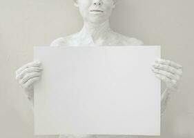 em branco Projeto poster modelo. mulher coberto com branco pintura segurando uma papel. foco em mãos. foto