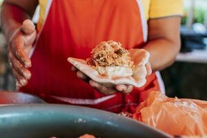 vendedora mostrando tradicional cru pupusa. elaboração do tradicional pupusas, elaboração do a massa para tradicional pupusas foto