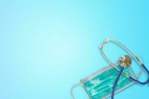 médico mascarar e estetoscópio em gradiente azul fundo com cópia de espaço para texto. protetora do coronavírus e gripe foto