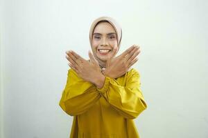 jovem ásia muçulmano mulher cruzando mãos faz Pare gesto e demonstra rejeição foto
