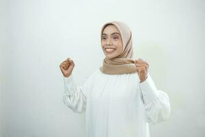 animado ásia muçulmano mulher a comemorar vitória isolado sobre branco fundo foto