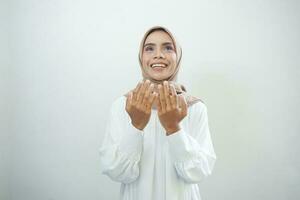 retrato do ásia muçulmano mulher Rezar com aberto braço isolado sobre branco fundo foto
