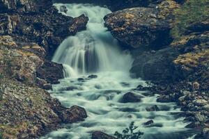 cênico cascata dentro rochoso norueguês montanhas foto