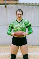 retrato do mexicano mulher americano futebol jogador vestindo uniforme com velociraptor pele padrões foto