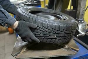 pneu serviço. a mecânica mãos aguarde a roda do a carro. roda reparar. foto