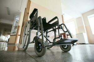 uma cadeira de rodas contra a fundo do a esvaziar hospital corredor. foto