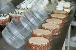 uma linha do pronto bolos dentro uma confeitaria fábrica. doces Produção. foto