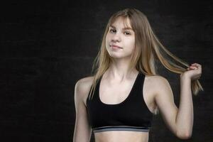 Adolescência menina dentro uma Esportes camisa em uma Sombrio fundo. foto