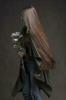 lindo morena menina com muito grandes e suave cabelo em uma cinzento fundo. luxuoso cabelo comprimento. foto