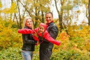 feliz família caminhando em a rural sujeira estrada. pequeno menina sentado em do pai ombro foto