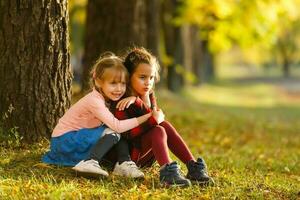 dois pequeno menina amigos estudante dentro a parque. foto