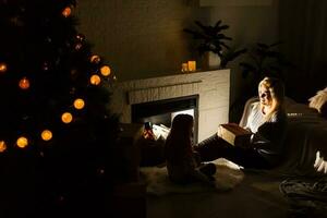 mãe e filha estão feliz juntos às Natal. Natal, natal, inverno, felicidade conceito - mãe e filha. família dentro Natal. esperando para Natal. feriado interior foto