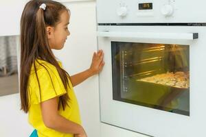 pequeno menina faço biscoitos às a advento tempo. foto