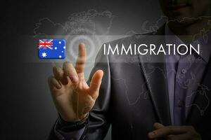 Austrália imigração conceito. homem pressionando virtual botão com bandeira ícone foto