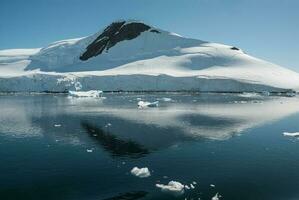 lemaire estreito costa, montanhas e icebergs, antartica foto