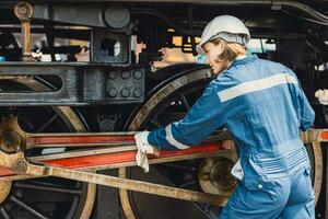 trem engenheiro equipe trabalhando serviço manutenção velho sujo vintage clássico vapor motor locomotiva dentro trem reparar oficina às trem estação. foto