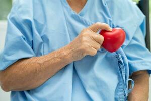 médico segurando uma vermelho coração dentro hospital, saudável Forte médico conceito. foto