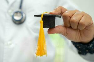 estudo de médico asiático aprende com chapéu de graduação na enfermaria do hospital, conceito de medicina de educação de gênio brilhante inteligente. foto