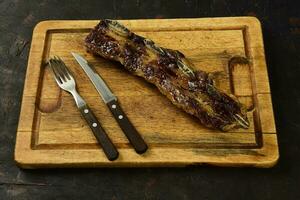 assado carne costelas apresentado em a mesa, tradicional Argentino cozinha, asado churrasco, Patagônia, Argentina. foto