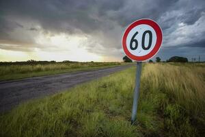 máximo Rapidez estrada placa com uma tormentoso céu fundo, la pampa província, Patagônia, Argentina. foto