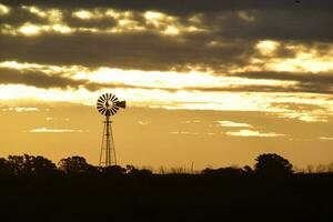 panorama com moinho de vento às pôr do sol, pampas, Patagônia, Argentina foto