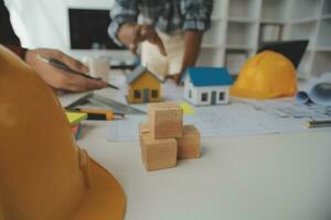 conceito de construção e estrutura de reunião de engenheiro ou arquiteto para projeto trabalhando com parceiros e ferramentas de engenharia na construção de modelo e projeto no local de trabalho, contrato para ambas as empresas. foto