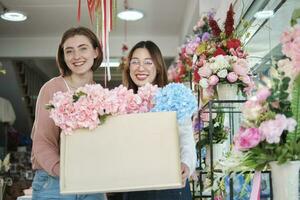 retrato do dois jovem lindo fêmea floristas com floral grupo entrega, sorridente e olhando às Câmera, adorável o negócio empreendedor, flor fazer compras feliz trabalhar, brilhantemente colorida flora ramalhete loja. foto