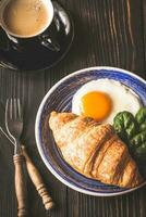 frito ovo com croissant e uma copo do café foto