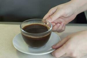 mulheres mãos aguarde uma copo do café sobre a mesa. café da manhã com café. faço café dentro uma turco. foto