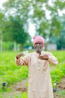 indiano agricultor segurando gullak dentro mão, salvando conceito, feliz pobre agricultor foto