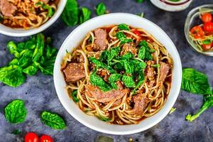 Macarrão com carne e hortelã em topo foto