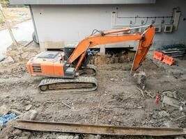 a ampla laranja escavadora dentro a local para construção. foto