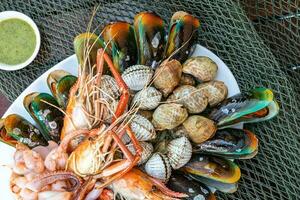 frutos do mar camarão mexilhão em prato e Sombrio cozido em fundo Comida foto