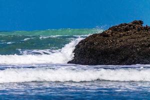 ondas fortes rolando na praia de bethels. Auckland, Nova Zelândia