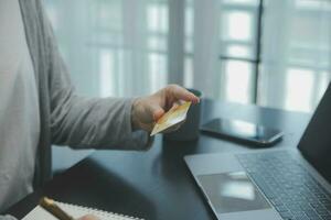 mulheres segurando crédito cartão e usando smartphones às casa.online compras, Internet bancário, loja on-line, pagamento, gastos dinheiro, comércio eletrônico Forma de pagamento às a loja, crédito cartão, conceito foto