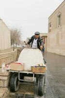 bucara, uzbequistão. dezembro 2022. vendedor do quente samsa a partir de tandoor em a rua do a velho Cidade foto