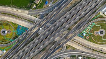 vista aérea superior da rodovia, estrada de junção da cidade de transporte com carro na interseção cruzada filmado por drone foto