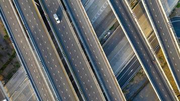 vista aérea superior da rodovia, estrada de junção da cidade de transporte com carro na interseção cruzada filmado por drone foto